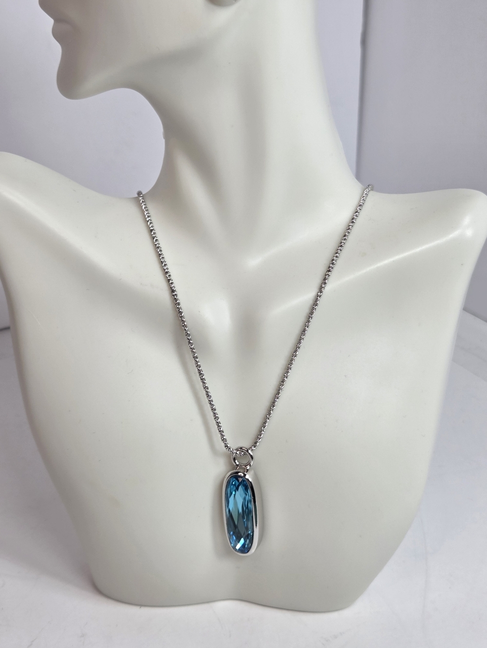 MIKA Silver tone Necklace with Blue Crystal long oval Pendant icy sea blue 20in